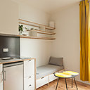 La cuisine aménagée avec des éléments Ikea est encadrée de panneaux en contreplaqué de bois filmé stratifié. Ses placards s’intègrent dans la continuité du coin salon comme si tout avait été réalisé sur mesure.