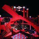 Intérieur du Flash Back, à Borgo Dalmazzo en Italie. Cet espace conçu par le Studio 65 intégrait un ensemble complexe d’escaliers rouge vif et de colonnes, évoquant les dessins de prisons de Giovanni Battista Piranesi, qui surplombait une piste de danse éclairée. Intérieur du Flash Back, à Borgo Dalmazzo en Italie. Cet espace conçu par le Studio 65 intégrait un ensemble complexe d’escaliers rouge vif et de colonnes, évoquant les dessins de prisons de Giovanni Battista Piranesi, qui surplombait une piste de danse éclairée.