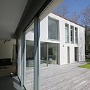 La façade sud minérale et vitrée offre un autre visage et une vue sur le jardin.