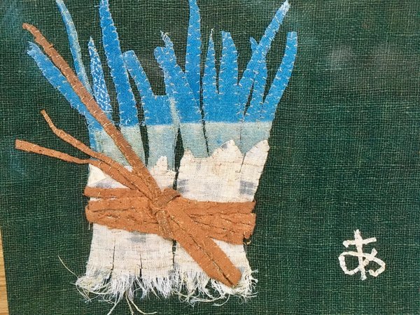Une botte de poireaux, oui mais avec du blanc en rubans de dentelle et un lien en raphia, oeuvre d'Ayako Miyawaki.