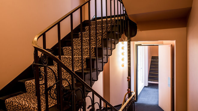 Un tapis façon fourrure de léopard offre sa sensualité féline aux marches de l’escalier, riches de sens.