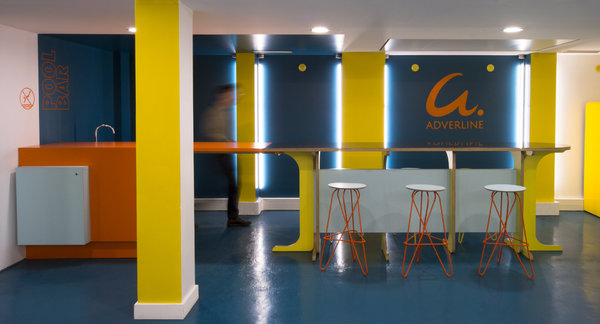 Bar de la salle de détente la société Adverline avec un jeu de couleurs graphiques qui dynamisent l’espace en sous-sol.