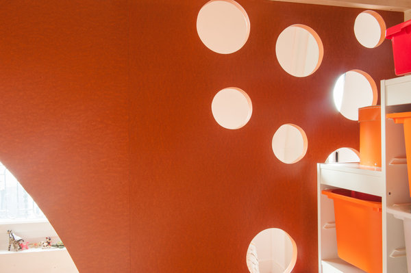 Les perforations de l’écran en Médium teinté dans la masse et vernis servent de prises de main et de pied à l’enfant pour monter et descendre de la mezzanine.