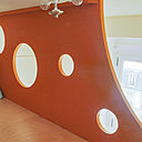 Autour du lit, de l’espace pour jouer comme dans une cabane. Les perforations permettent aussi à la lumière naturelle de pénétrer dans l’espace de la mezzanine.