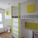 Un espace partagé par un bloc de rangement qui sert de pilier au double couchage.