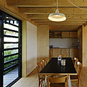 La cuisine intégrée en bois se confond avec les murs recouverts de panneaux MFP.