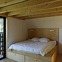 Au second niveau, une des chambres monacales avec lit sur podium intégrant des rangements.