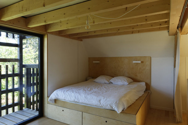 Au second niveau, une des chambres monacales avec lit sur podium intégrant des rangements.