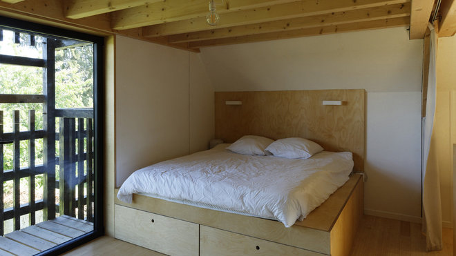 Au second niveau, une des chambres monacales avec lit sur podium intégrant des rangements.