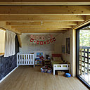 Au second niveau, une chambre d’enfants avec un vaste espace libre pour jouer. Des rideaux isolent la pièce du reste du volume.