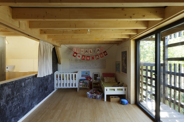 Au second niveau, une chambre d’enfants avec un vaste espace libre pour jouer. Des rideaux isolent la pièce du reste du volume.