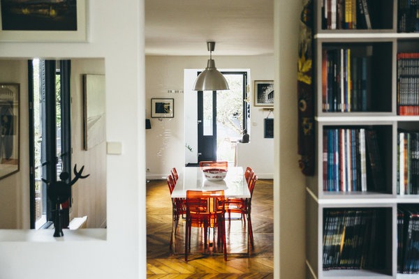 Au rez-de-chaussée, la salle à manger s’ouvre sur le salon. On a conservé le parquet ancien en épi valorisé par la couleur des chaises et le blanc des murs.