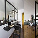 Une tablette multifonction en métal installée sous la verrière sert de coin bureau et de coin repas, en fonction des horaires. Tabourets, Tolix. Suspension Modular. L’entrée est éclairée par la lumière de la verrière. Chaises Eames Plastic Side Chair DSR, création Ray et Charles Eames éditée par Vitra.