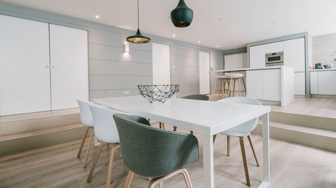 La décoration et le design du loft ont été travaillés dans un esprit graphique qui se fond avec les murs. Luminaires Tom Dixon, fauteuils Hay. Table de salle à manger dessinée sur mesure par l’architecte d’intérieur Carl Tran.