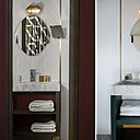 Dans les salles de bains, au-dessus du miroir (Petite Friture), applique murale étanche d’esprit industriel (Zangra). Vasque en marbre moucheté, carrelage reliéfé effet 3D avec baguettes en laiton.