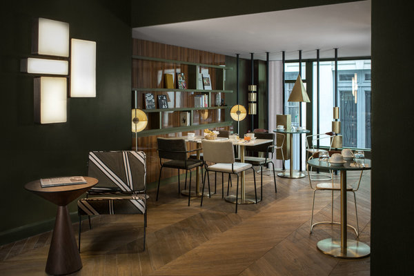 Jeux de volumes géométriques et de pleins de vides entre le mobilier et les luminaires très présents dans le lobby de l’Hôtel Louvre Piémont.