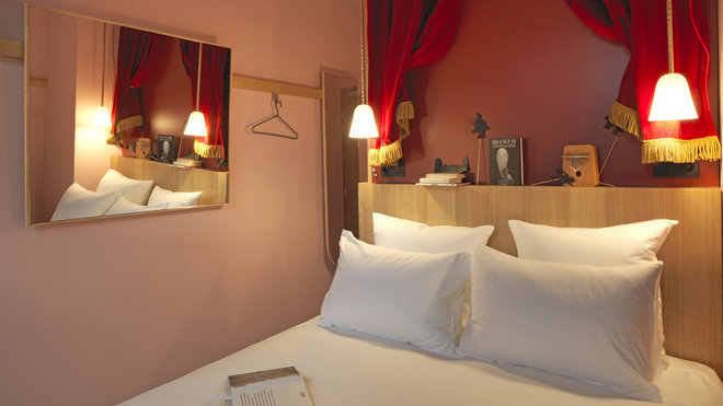 Dans les chambres avec rideau de théâtre en tête de lit, les cintres accrochés sur des patères permettent de ranger les vêtements.