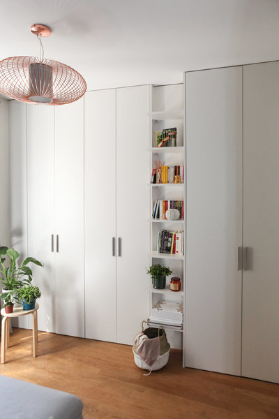 Dans cette chambre d’amis, un canapé lit et des rangements immaculés qui épousent les murs et reflètent la lumière.