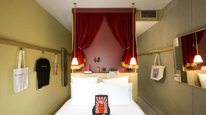 Tête de lit théâtrale pour cette chambre où le rangement s’effectue sur des patères murales pour dégager l’espace au sol pour le lit.