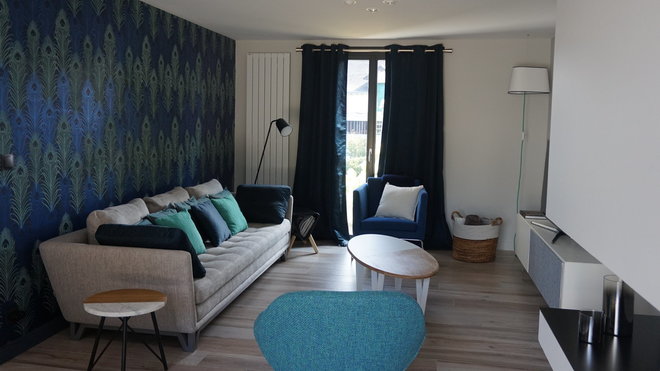 Canapé Roche-Bobois. Coussins bleu foncé faisant écho à la couleur des rideaux. Table basse, création Guillaume Redois.  Guéridon, Nutsandwood.