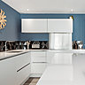 Les murs de la cuisine sont recouverts d’un bleu mat doux (La Seigneurerie). Carrelage noir mat et brillant, Diamond chez Soleras.