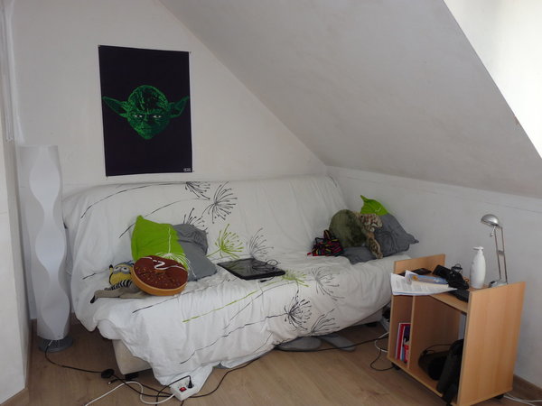 La chambre de la fille avant les travaux : un espace meublé avec un canapé convertible.