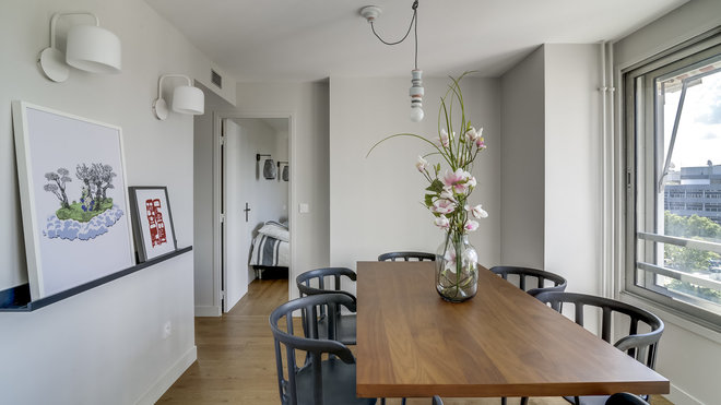 La salle à manger s’intègre parfaitement dans l’espace et profite de la clarté exceptionnelle diffusée par les larges fenêtres. Table avec plateau en placage de noyer, AM.PM. Chaises avec accoudoirs, Ikea PS 2012.