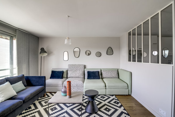 Salon aménagé avec un canapé fixe et un modèle composé d’éléments modulables et juxtaposables (Ikea). Suspension, Portobello.