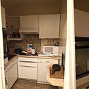 Avant les travaux, l’ex-petite cuisine fermée peu fonctionnelle et très encombrée avec des meubles en angle.  Elle n’offrait qu’un plan de travail réduit et une toute petite table d’appoint en complément.