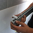 Etape 1 : Pose des supports sur le store vénitien, en clipsant le support aluminium sur le cadre.