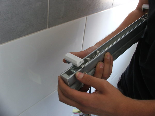 Etape 1 : Pose des supports sur le store vénitien, en clipsant le support aluminium sur le cadre.