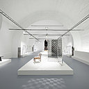 A droite de la Fade Out-chair, avec pieds en acrylique peint en dégradé qui crée un effet aérien, paravent Fragment en aluminium et cristal extra-light trempé avec décor de damiers rectangulaires et effet de miroir double face. Création Nendo éditée par Glas Italia.