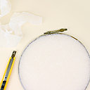 Encoller le bord du cercle, tendre le papier de soie bien tendu, rabattre et découper les excédents.