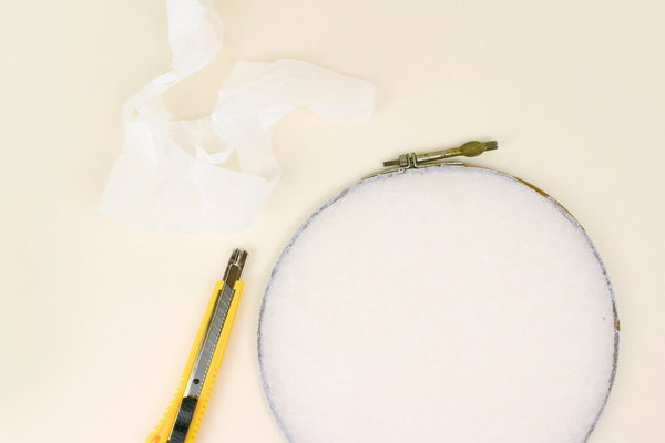 Encoller le bord du cercle, tendre le papier de soie bien tendu, rabattre et découper les excédents.