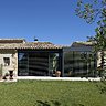 L’extension se compose de grandes baies coulissantes Soleal qui prennent appui sur l’avancée de toit de l’ancienne terrasse. Elles ouvrent le salon sur l’extérieur et permettent aux occupants de profiter de la vue sur le jardin, été comme hiver.