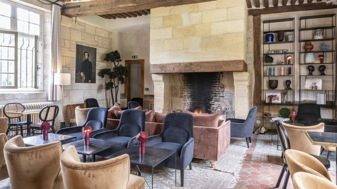 Le grand salon accueille les visiteurs avec sa cheminée monumentale, ses fauteuils profonds et un savant éclairage ponctué de petites lampes nomades Bicoca de chez Marset signées du designer Christophe Mathieu.