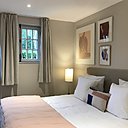 Tonalités douces et naturelles pour les chambres des cottages, rehaussées de touches de noir et de vieux rose.