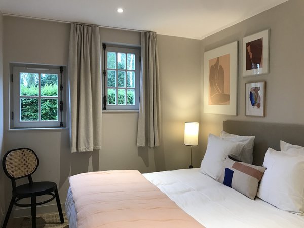 Tonalités douces et naturelles pour les chambres des cottages, rehaussées de touches de noir et de vieux rose.