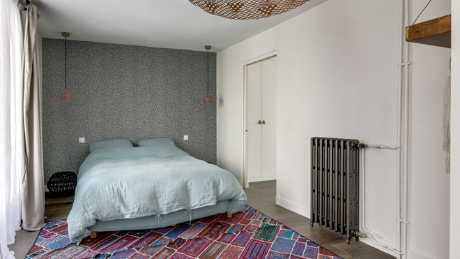 Dans la chambre, un tapis vintage façon patchwork. Au plafond, suspension Cohen chez Frandsen. De part et d’autre du lit, suspensions en cuivre rose laqué, Fleux’.