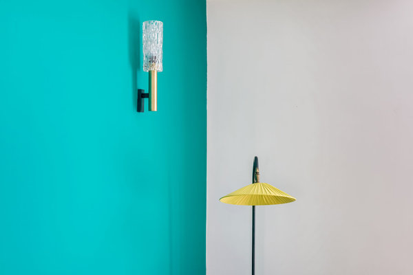 Dans la partie salon, applique lumineuse vintage, Selency et lampadaire chiné en brocante sur mur peint en vert (coloris Diabolo SL 36 chez Ressource).