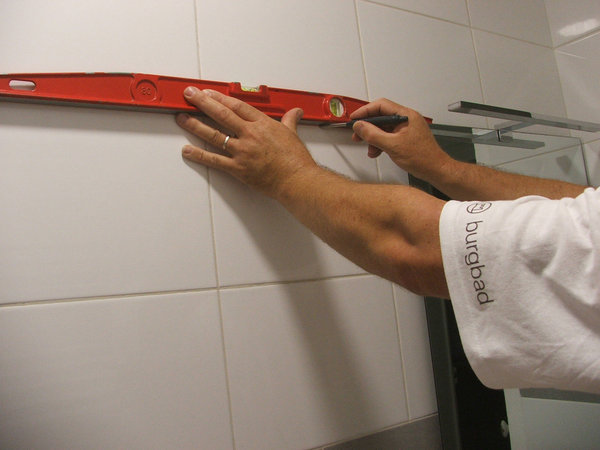 Etape 2 : à l’aide d’un niveau, tracer les repères afin de mettre à niveau le rail de fixation du meuble haut.