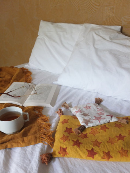 Un coussin blanc ou un coussin jaune étoilés en impression à la pomme de terre, remplis de noyaux de cerises, soulageront vos maux.