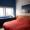 Dans la chambre, un mur peint met en valeur la fenêtre qui offre une vue cadrée sur l’extérieur.