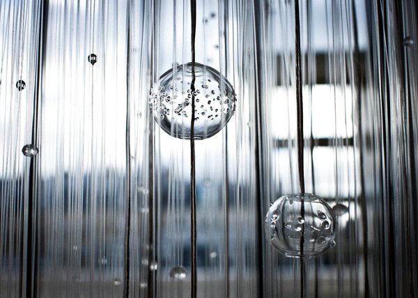 Inspiré par la nature, gouttes, boules, fibres, pluies de verre et de lumière détail sur le lustre Lluvia qui offre une vision spectaculaire de la transparence. Création Myriam Roland-Gosselin pour Verart.