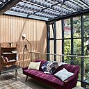 Entre ciel et terre, une grande verrière, au centre de la maison, abrite des espaces partagés pour se détendre et échanger (bibliothèque, salon...).