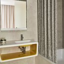 Couleurs minérales pour la salle de bains avec une touche de couleur vive comme le jaune qui ponctue la vasque avec rangement intégré.