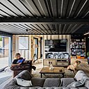 Avec des baies vitrées exposées au sud, la maison se chauffe par elle-même et les radiateurs se coupent automatiquement à 20°. Canapé Maison du Monde, sol stratifié Leroy Merlin et table basse fabriquée par le père de Killian à l’âge de 14 ans dans le cadre de son CAP.