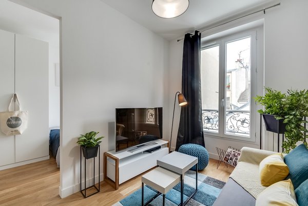 Le salon communique avec la chambre semi-ouverte et le mur mitoyen cache le lit.