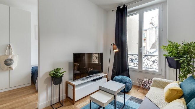 Le salon communique avec la chambre semi-ouverte et le mur mitoyen cache le lit.