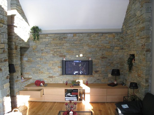 A l’intérieur de cette maison, les murs en grès, issus d’une carrière belge, offrent des teintes qui réchauffent les espaces contemporains et minimalistes. Réalisation GBA.